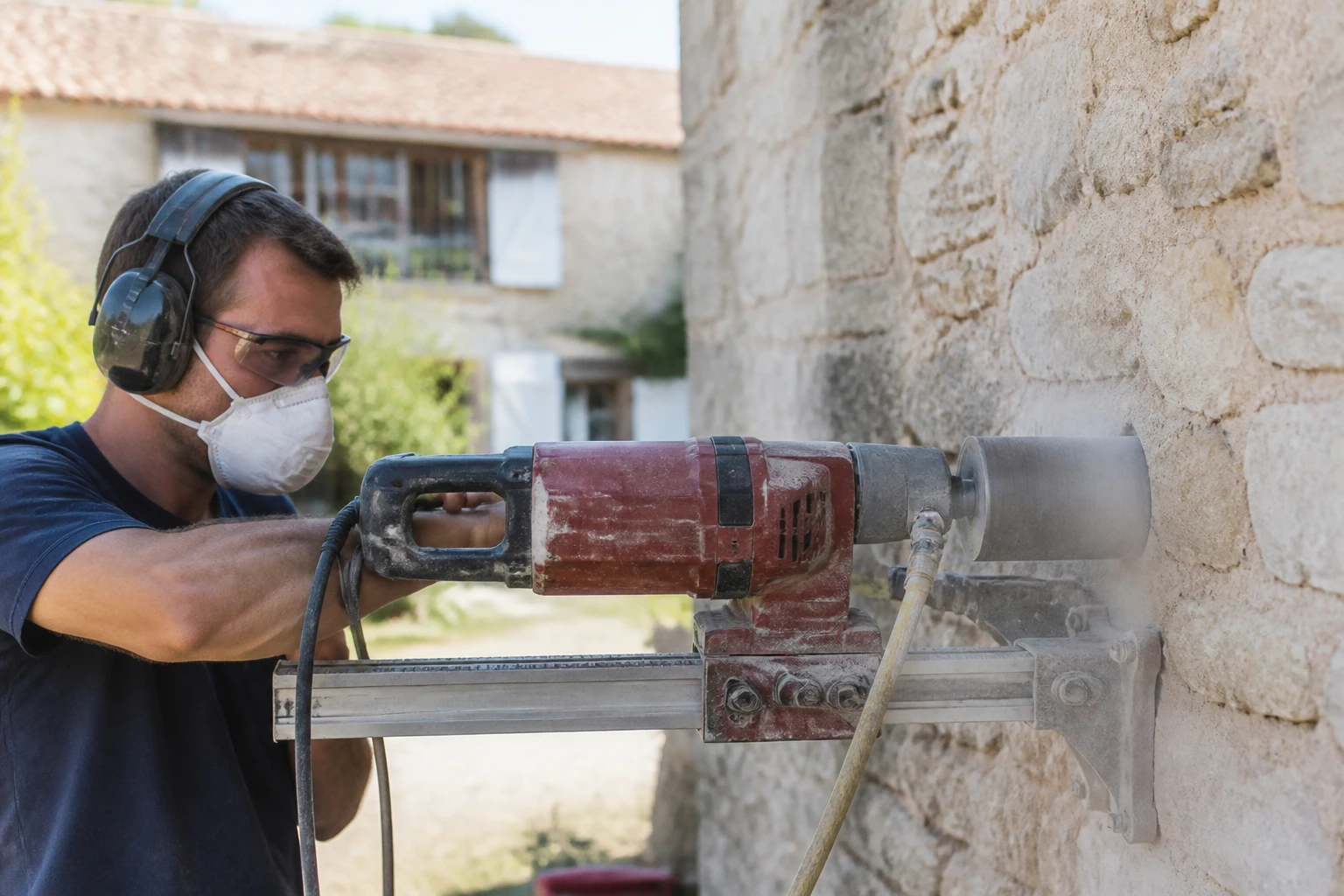 Artisan installant une grille de prise d'air dans un mur extérieur pour une cheminée à foyer ouvert